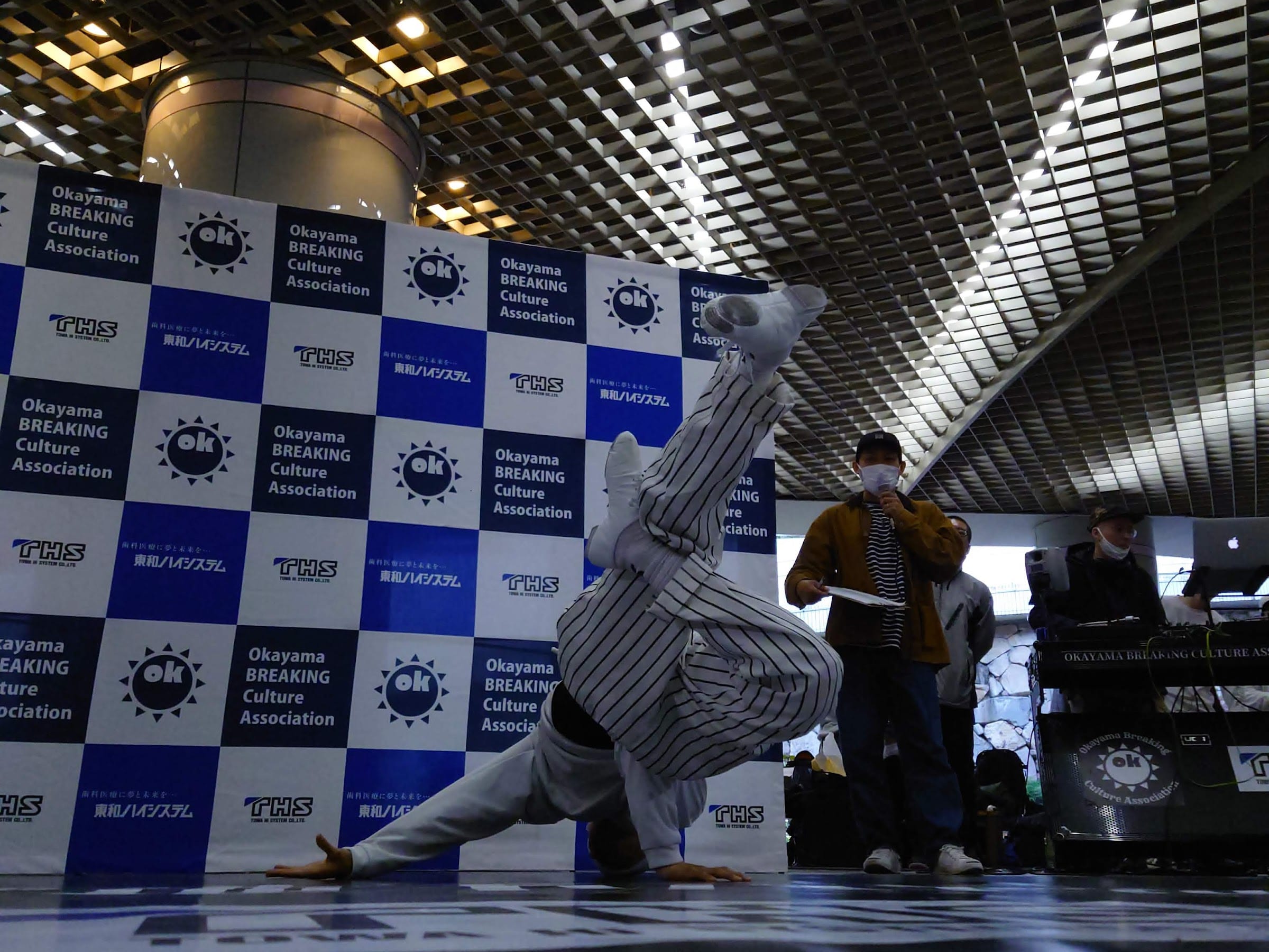 Two dancers squared up in a 1v1 battle at the center of the floor