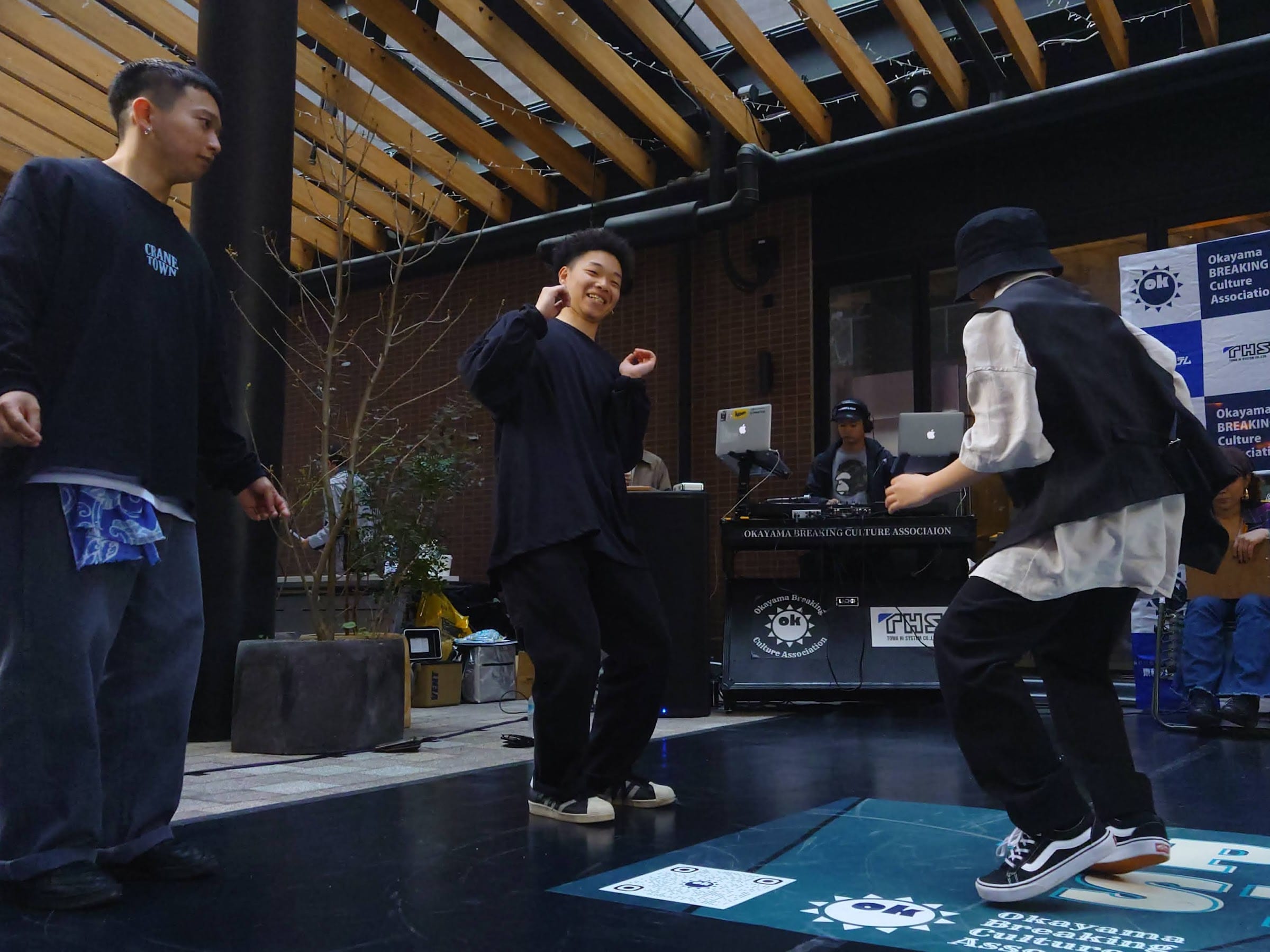 DJ ブース前で向き合う 3 人