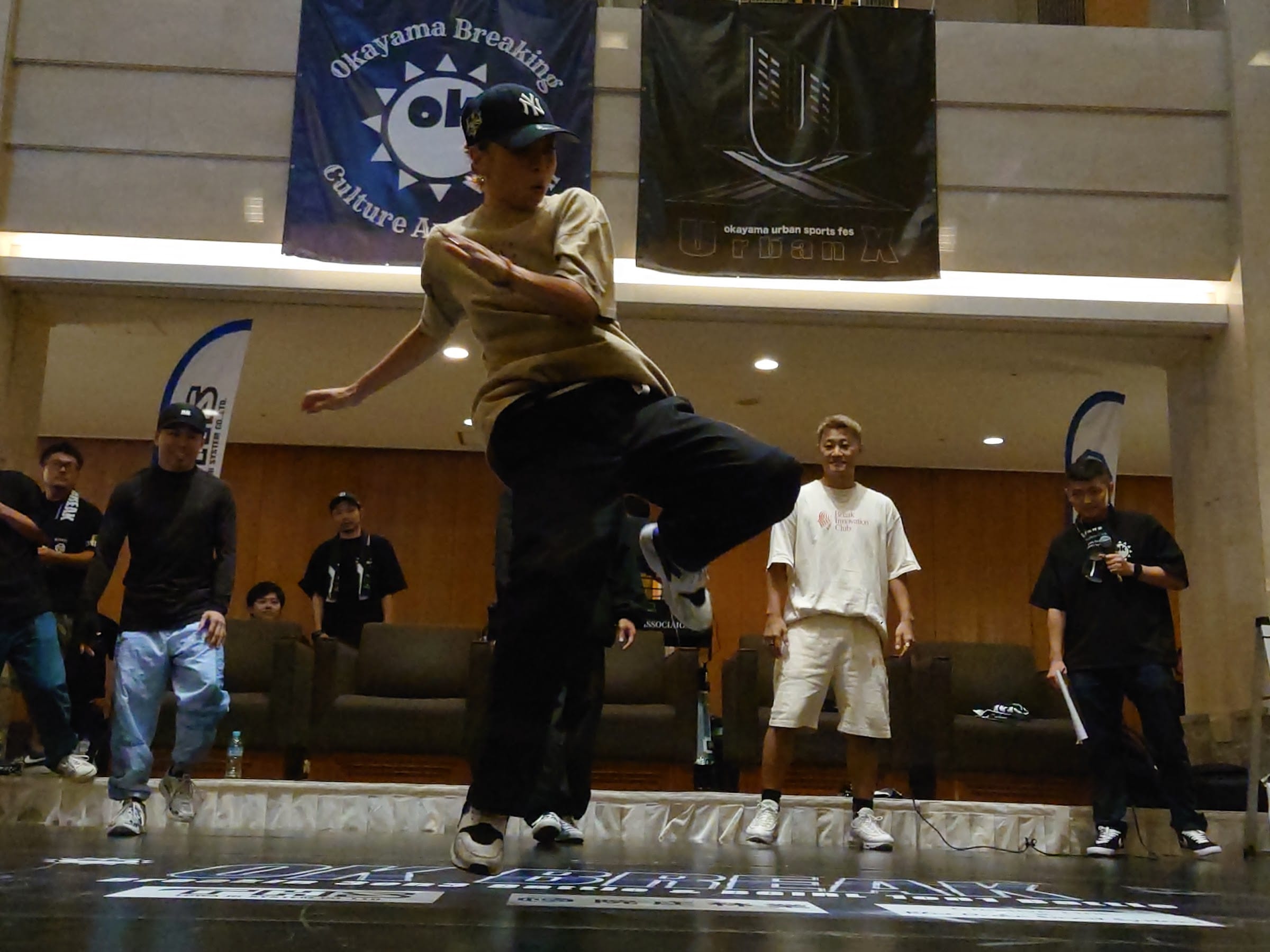 OK Breaking の看板を背景に動く B-Girl