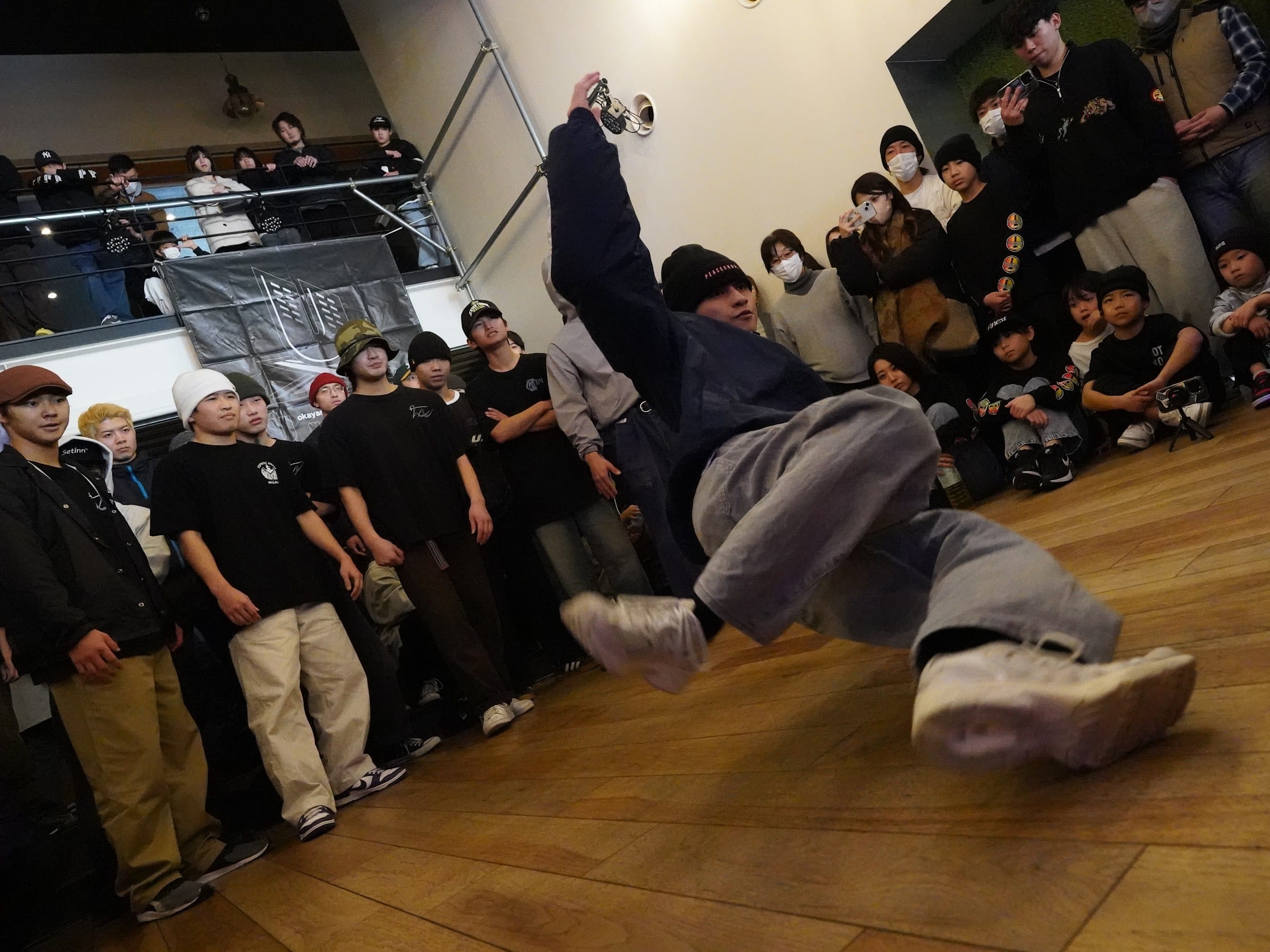 観客に囲まれてフリーズを決めるダンサー