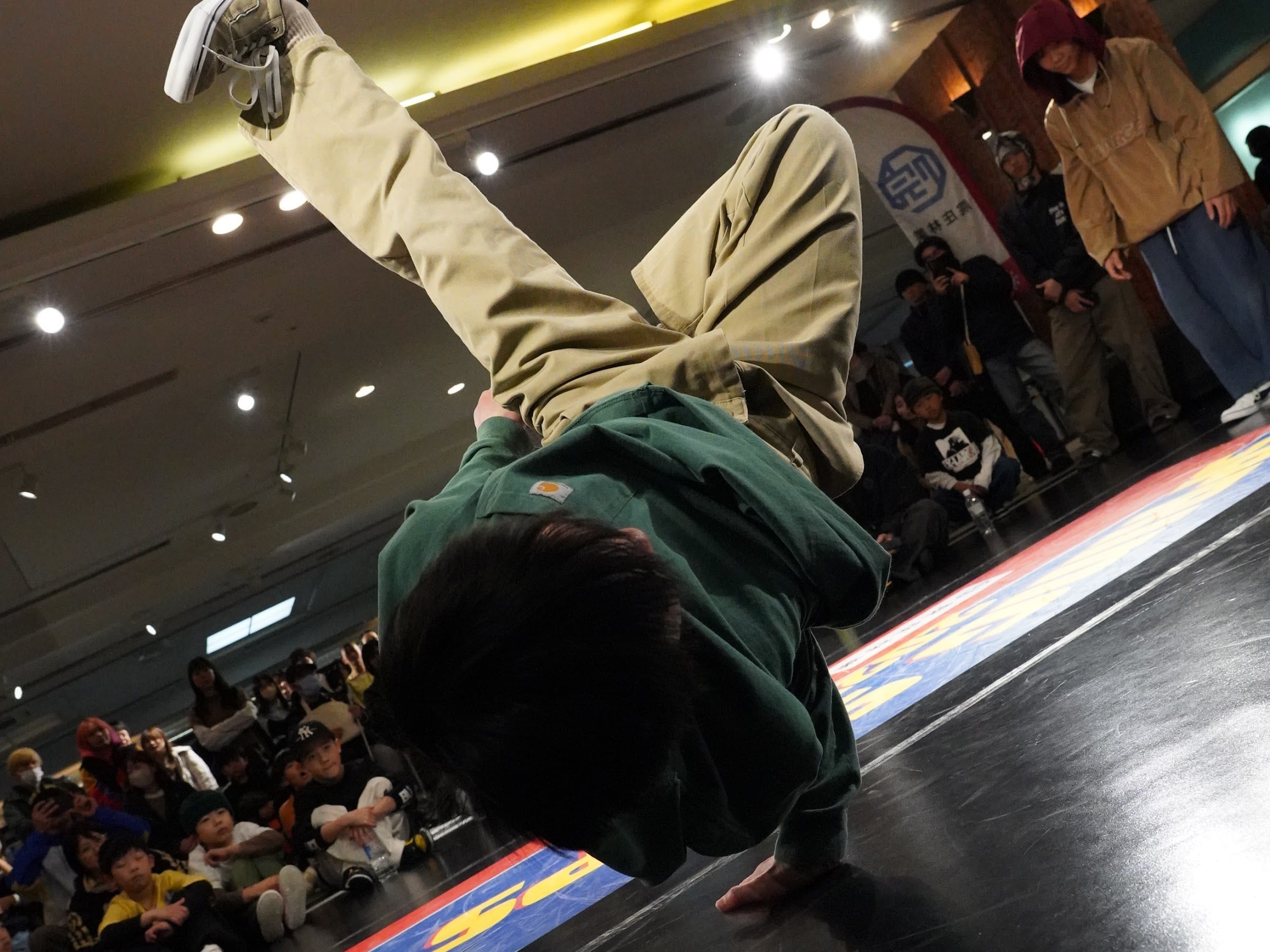 頭を下に倒した freeze で重力を耐えるダンサー
