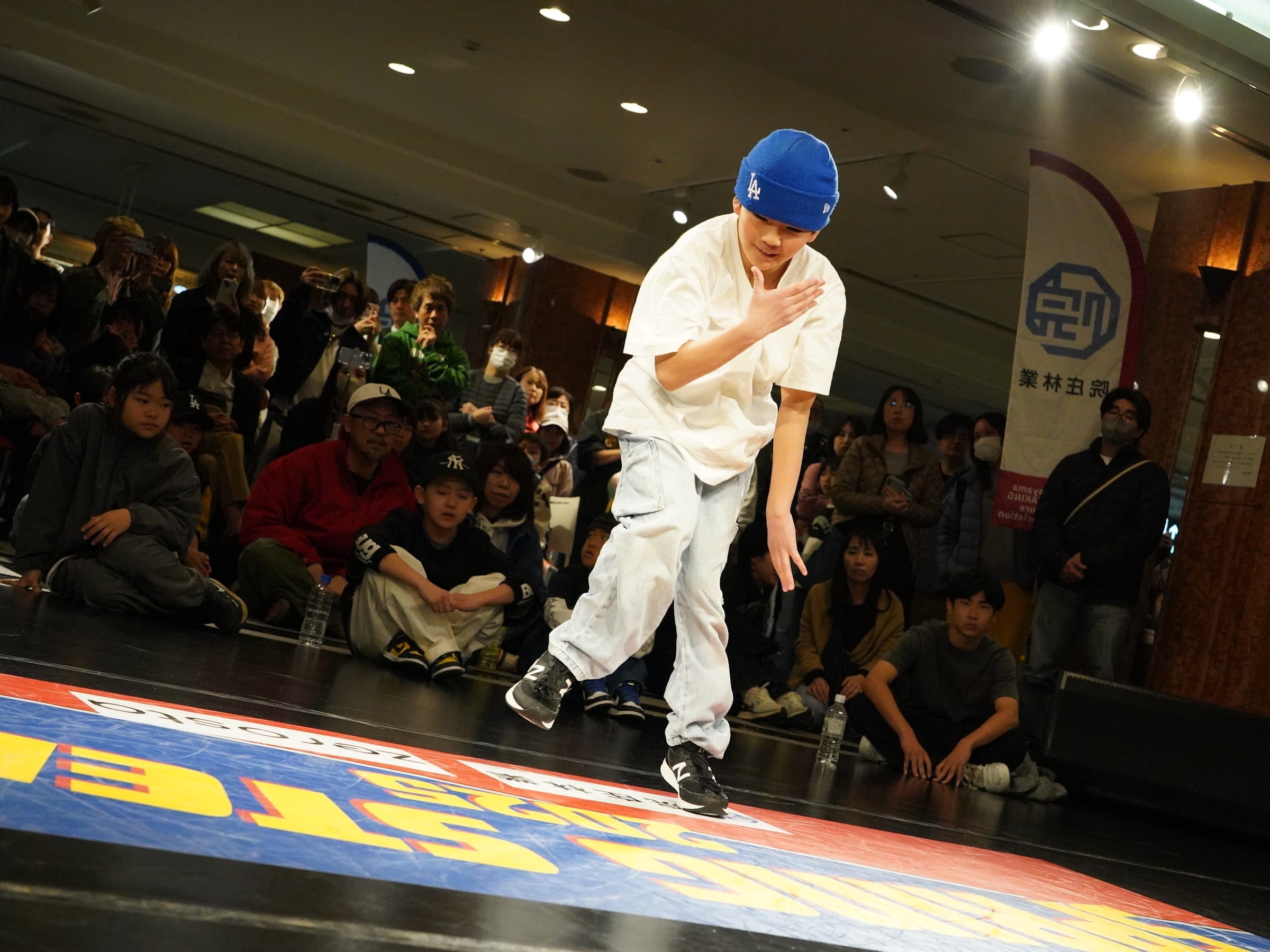 SPRING STEPS のロゴの上で handhop を見せるダンサー