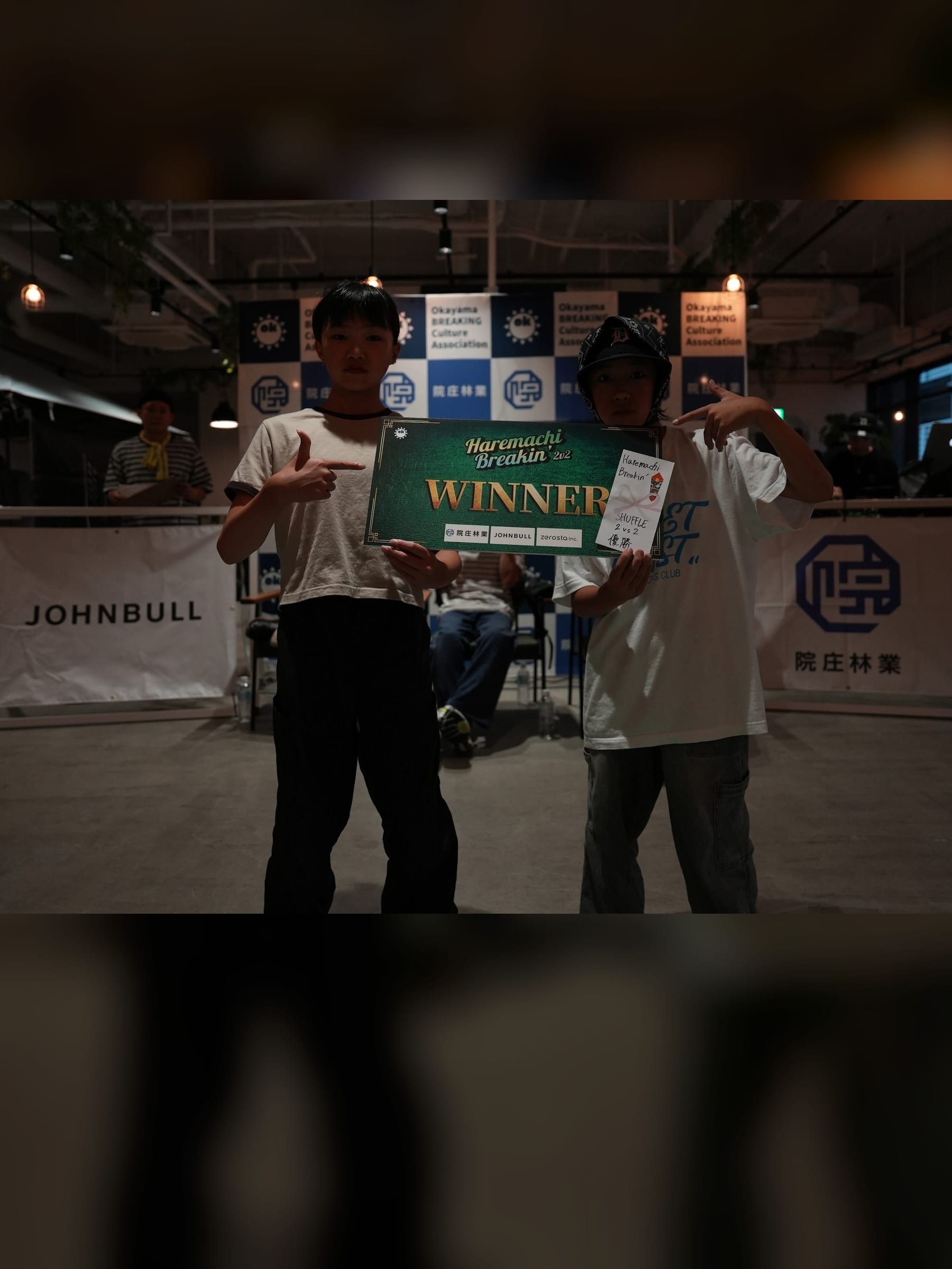 TK-ROCK and MEISA holding the WINNER board after the U15 Shuffle final