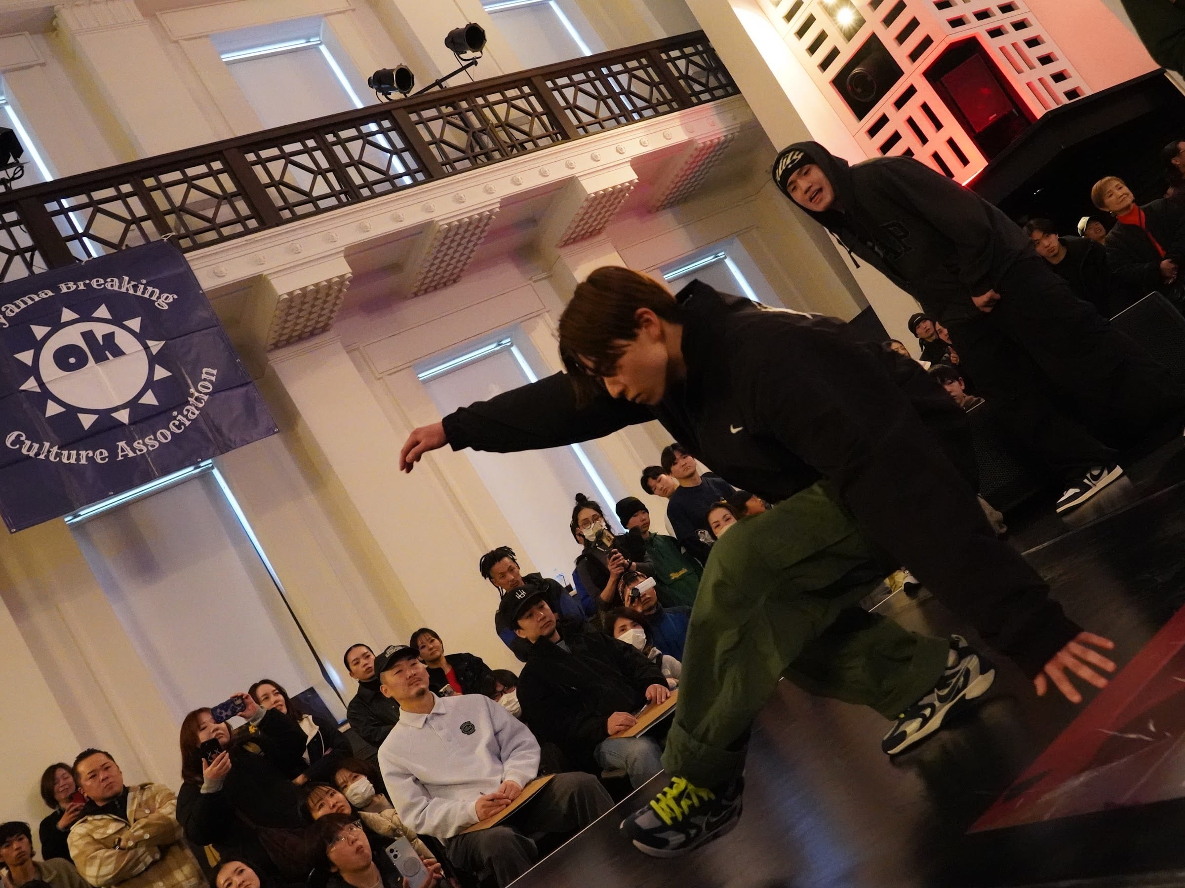 Okayama Breaking Culture Association のバナーを背に踊る U15 ダンサー